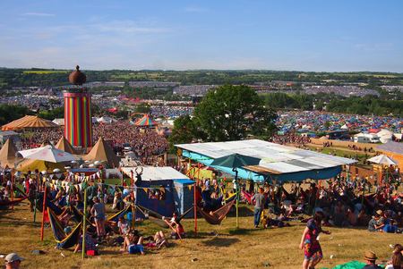 Pilton, United Kingdom - June 25, 2015: People sit on the hill and watch the crowds in the sunshine at a music festivalのeditorial素材