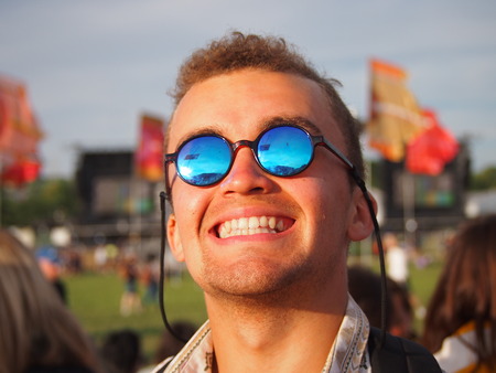 Pilton, UK - 22 June, 2017: A smiling, happy man at a music festival wearing sunglassesのeditorial素材