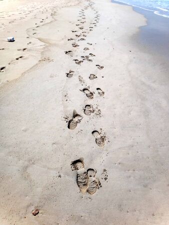 Footsteps in sand at beachの写真素材