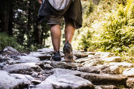 Man walking on the rocky path - behind detail close upの写真素材