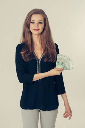 Young woman holds cash - Polish money - shopping, finances, loansの写真素材