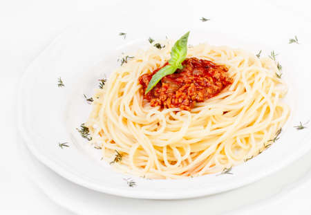 Spaghetti bolognaise with herbs on a white plateの写真素材