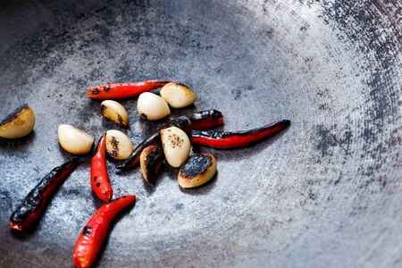 Grilled red chillies in a frying pan for cookingの写真素材