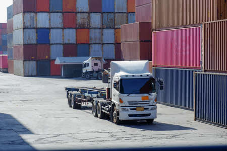 Container forklift truck in shipping yard for import export industrial logistics transport with container stacks in background.の写真素材