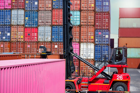 forklift truck Container boxes in a logistics yard with a stack of containers in the background.