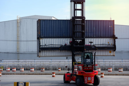 forklift truck Container boxes in a logistics yard with a stack of containers in the background.