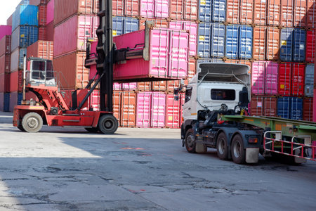 A container forklift sits behind a stack of containers.の写真素材