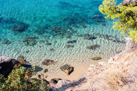Turquoise water and beach shot from above in a secluded Mediterranean bay shot from above in bright daylight in the summerの写真素材
