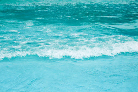 Sea waves foam lapping to coastal shore.