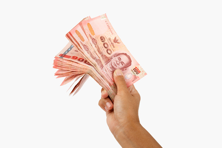 Female hand holds Thai paper money isolated white background.の写真素材