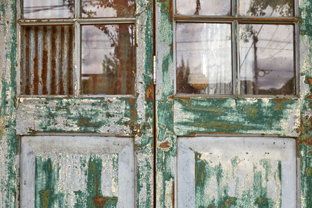 Closeup view of old wooden folding doors in vintage style with painting color peeled offの写真素材