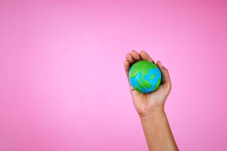 Earth model in women`s hand on pink background.の写真素材