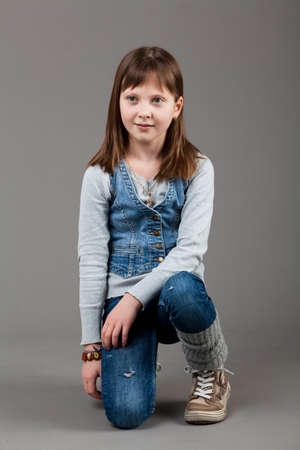 young happy girl.  little girl on a gray backgroundの写真素材