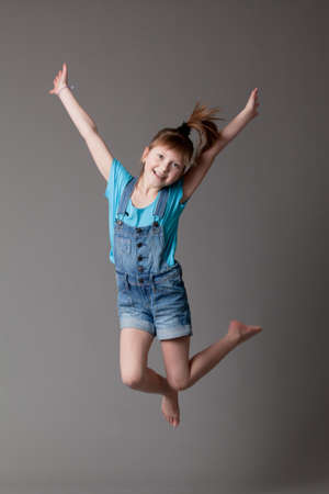 young happy girl   little girl on a gray backgroundの写真素材