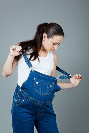 beautiful young pregnant woman in a dress with a gray backgroundの写真素材
