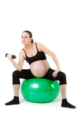 Beautiful pregnant woman sitting with exercise bal. Isolated on white backgroundの写真素材