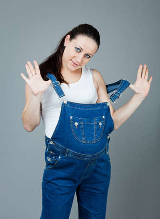 beautiful young pregnant woman in a dress with a gray backgroundの写真素材
