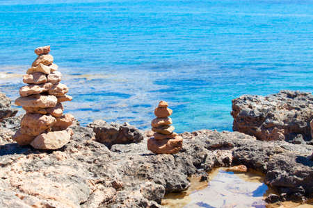 Balanced stones, pebbles stacks against blue sea.の写真素材