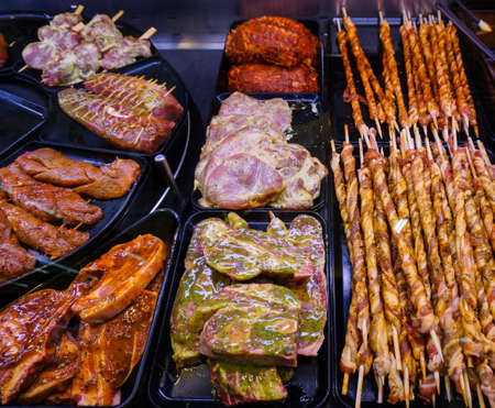 Marinaded meat for grilling in a counter display in a supermarket.  meat at the butcherの写真素材