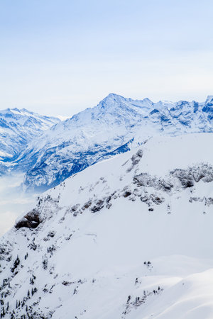 Winter snow covered mountain peaks in Europe. The Alps winter mountain landscape