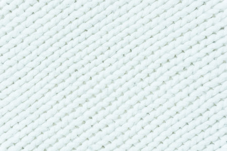 knitted fabric texture. Knitted jersey background with a relief pattern. Braids in knittingの写真素材