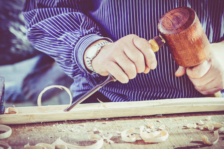 hands of the craftsman carve a bas-relief with a gouge. Craftsman hands working. Work Of Artist