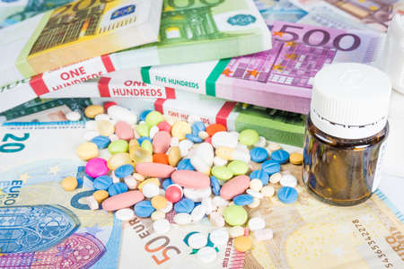 Money and pills. Pills of different colors on money. medicine concept. Euro cashの写真素材