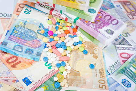 Money and pills. Pills of different colors on money. medicine concept. Euro cashの写真素材