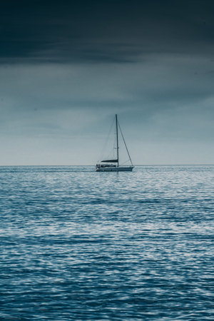 Sailing boat on Blue sea with heavy storm clouds. Sailing yacht raceの写真素材