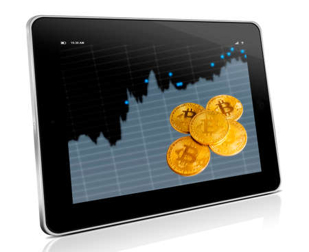 gold bitcoin and a tablet with charts of crypto currencyの写真素材