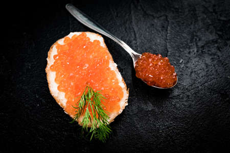 Red caviar with bread on blackの写真素材