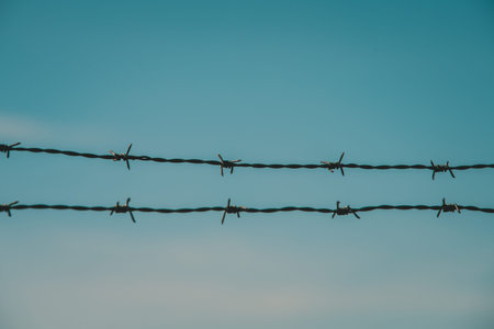 Barbed wire against blue sky