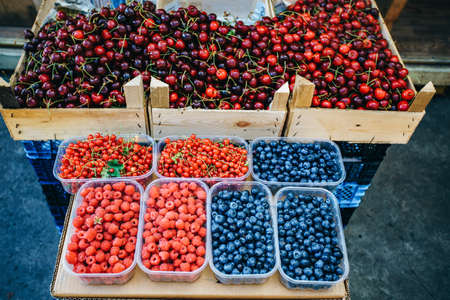 A mix of fresh berries on the market, strawberries, blueberries, raspberries, blackberries, cherries and red currantsの写真素材