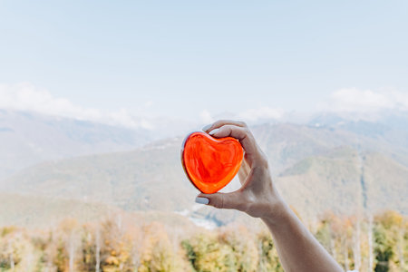 Person Holding Heart With Scenic Panorama Mountainの写真素材