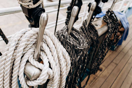Old sailboat, closeup of wooden cleats with nautical moored ropes.の写真素材