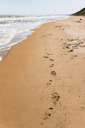 Footprints on beach background. A footprint of human feet on the sand near the seaの写真素材