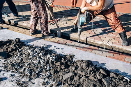 Workers laid paving slabs. Two workers lay paving slabs.の写真素材