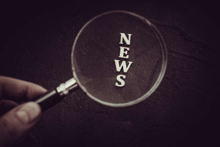 Focus on News.  News Word Magnifying Glass on black backgroundの写真素材
