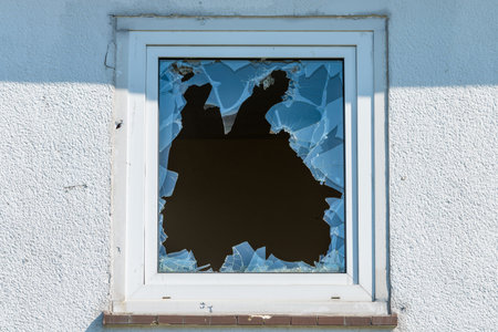 Broken window in a  building. The concept of vandalism