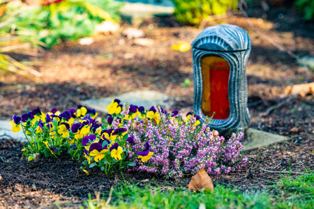 Grave light with candle on a grave with flowers