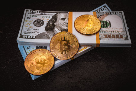 golden bitcoin metal coin on one US dollar bill