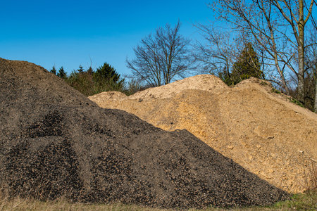 Piles of bulk industrial sand and gravel materialの写真素材