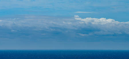 Panoramic view of bright blue sea, blue sky with fluffy white cloudsの写真素材
