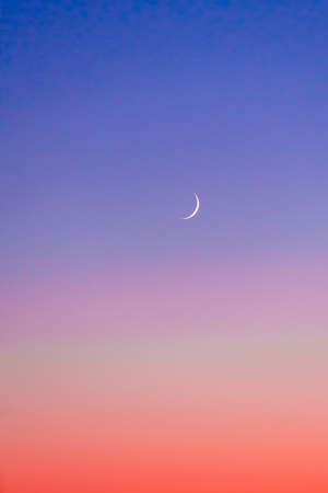 Crescent at the sunset sky. Sunset colors and new moon.の写真素材