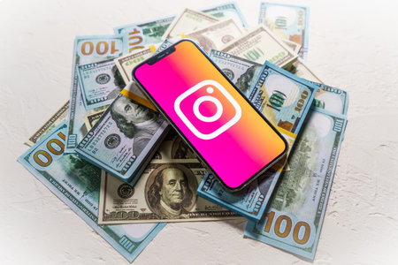 Berlin, Germany - February 02, 2022: Money and smartphone displaying the Instagram logo. social...