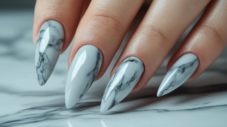 Glossy marble stiletto nails on an elegant female hand, exuding modern sophistication.の素材