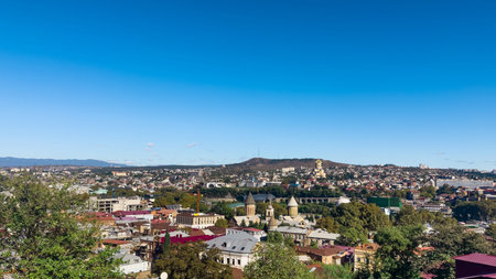 A wide aerial view of Tbilisi cityscape in Georgia featuring the Bridge of Peace across the Mtkvari...