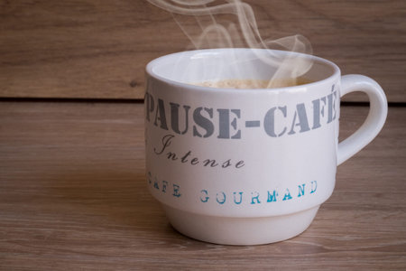 Hot coffee mug on a wood tableの写真素材