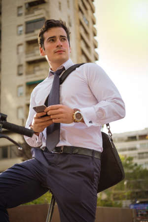 Young buinessman riding a bicycle to work in the city.の写真素材