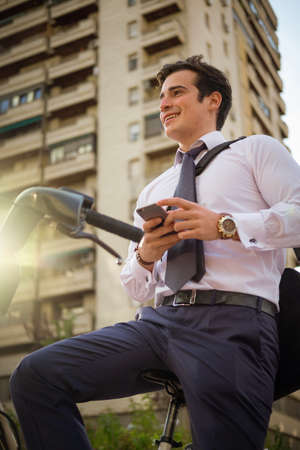 Young buinessman riding a bicycle to work in the city.の写真素材